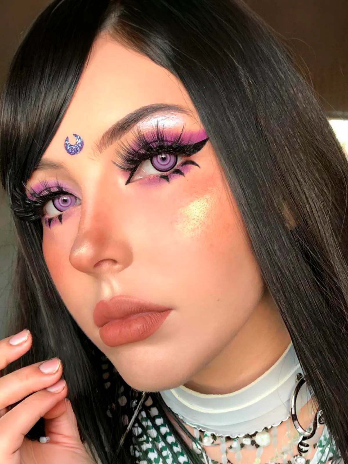 Modelo con lentes de contacto Sakuya color lila con anillos y maquillaje de fantasía